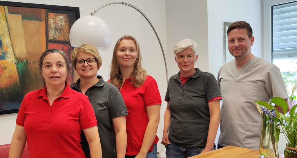 Tanja Stoll und Peter Boros vor dem Original-Logo dentArt Stoll GmbH